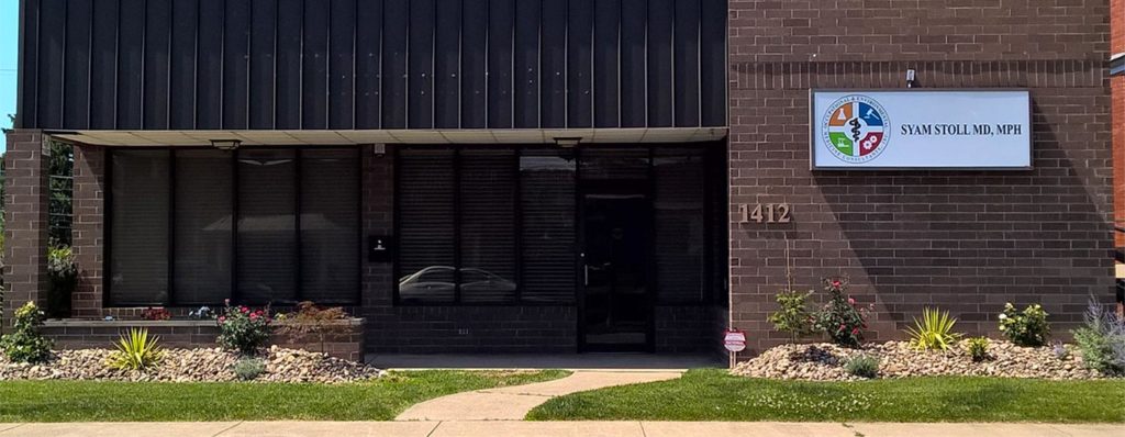 The OEMC office at 1412 6th Avenue, a brick building with the Syam Stoll MD, MPH sign